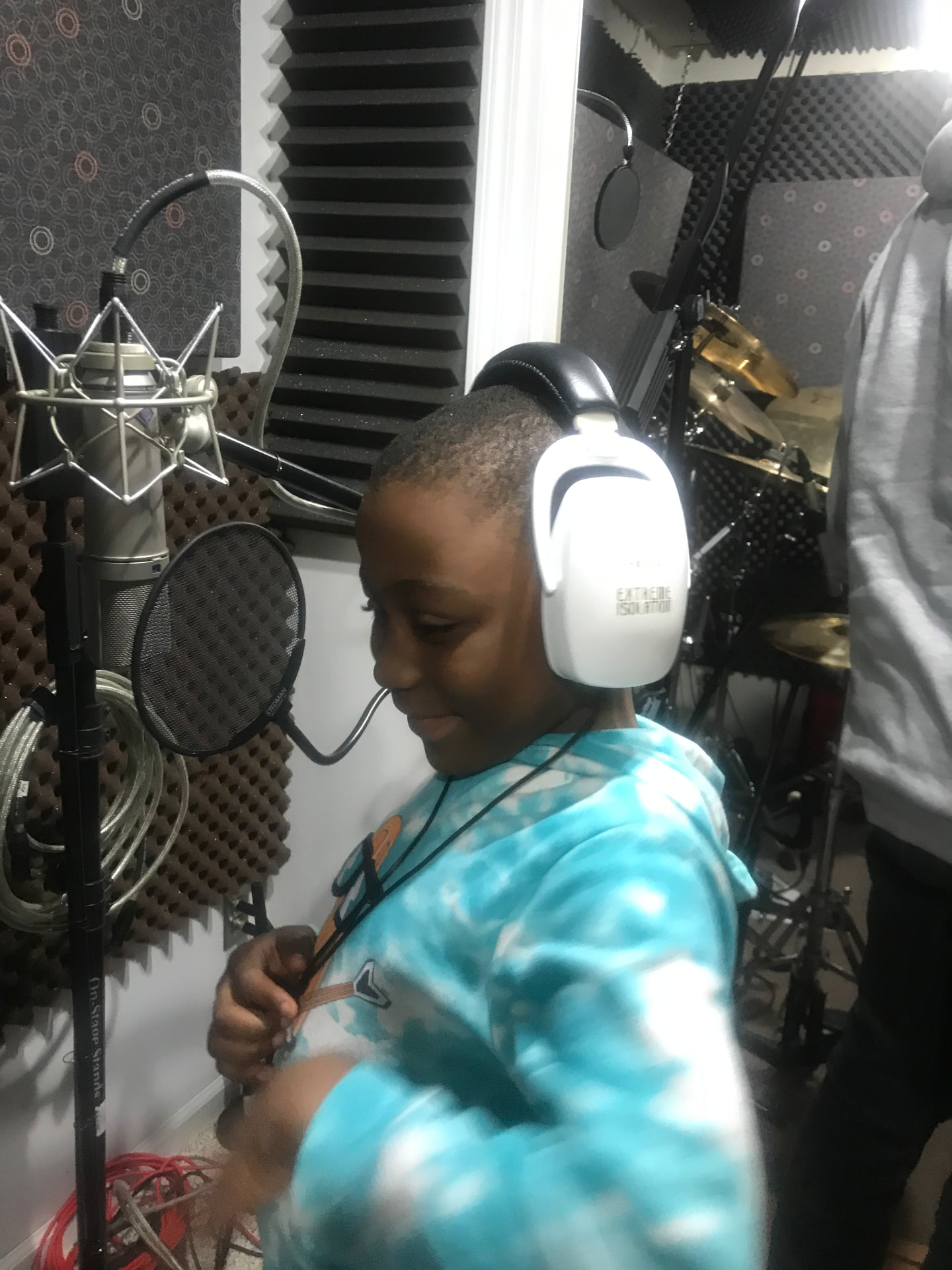 A FliKidz student recording vocals in a music studio